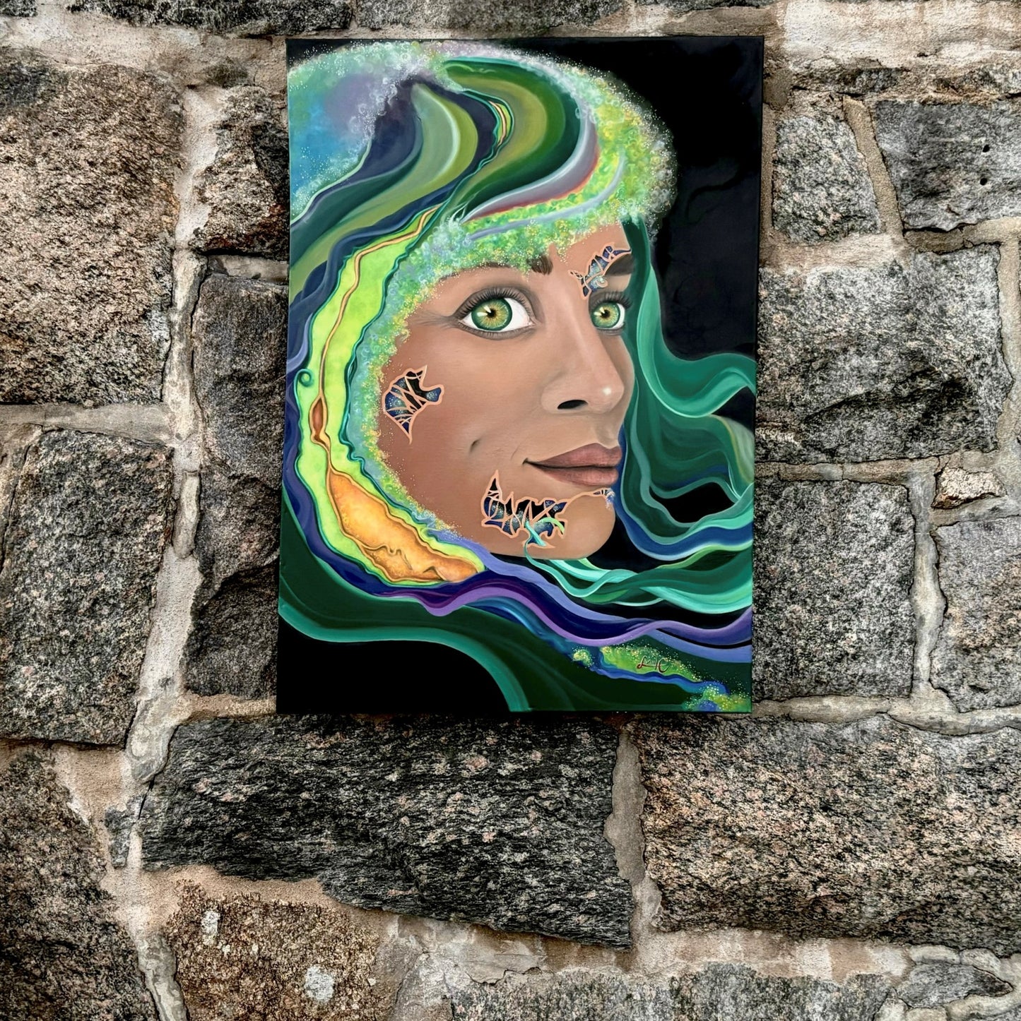 The oil painting "Sagan I/II: made of starstuff" from the series "SCIENK" from LVIIIH ART. Shows the creation of a beautiful & colorful face of a woman in space. Hangs against a rough-edged stonewall.